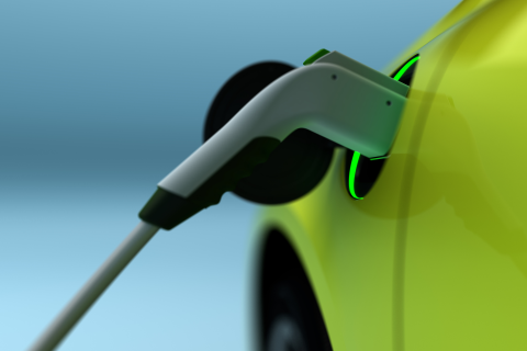 lime green electric car with electric charger plugged in